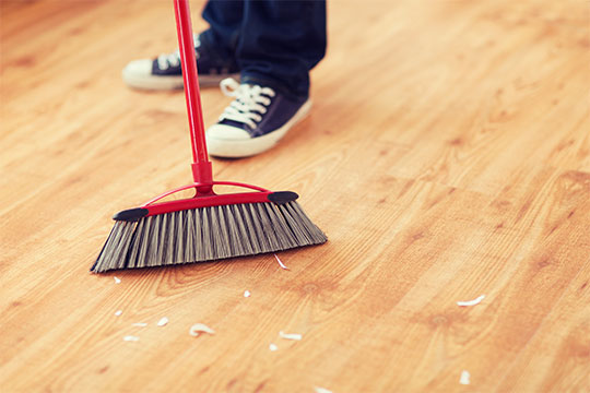 close up of broom sweeping floor