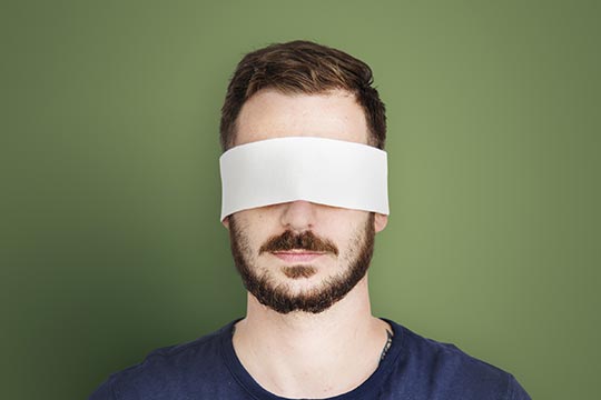 man's head wearing a white blindfold